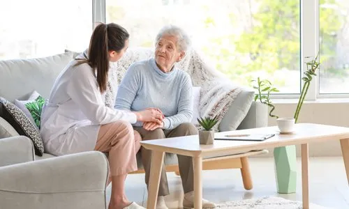 Caregiver sitting with an older adult at home