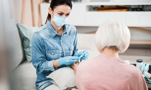 Caregiver checking an older adult’s blood pressure at home